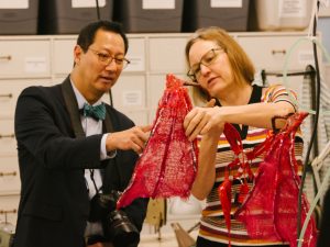 Jodi Jacyk shows President Ono a set of wings being repaired in Theatre &amp; Film's Costume Shop.